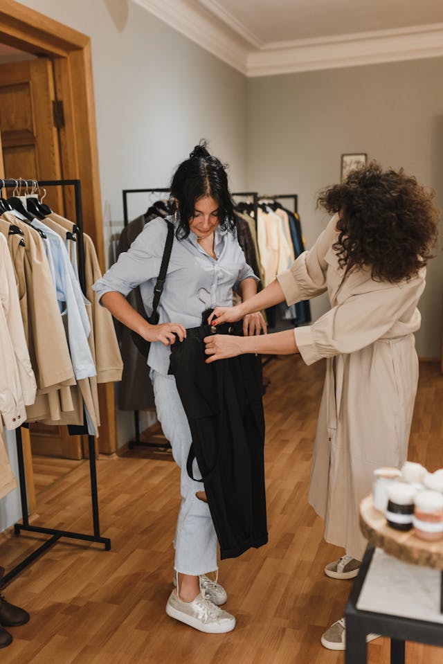 Two women shopping and picking out clothes—prepping stylish vacation outfit ideas.